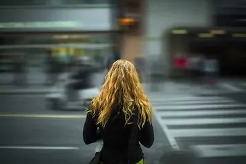 Passante traversant une rue commerçante